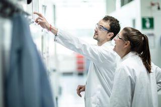 two scientists collaborating on a whiteboard